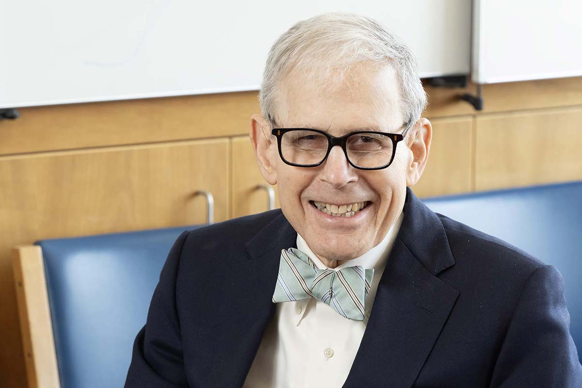 Barry Coller wears a bow tie and glasses and smiles into the camera.