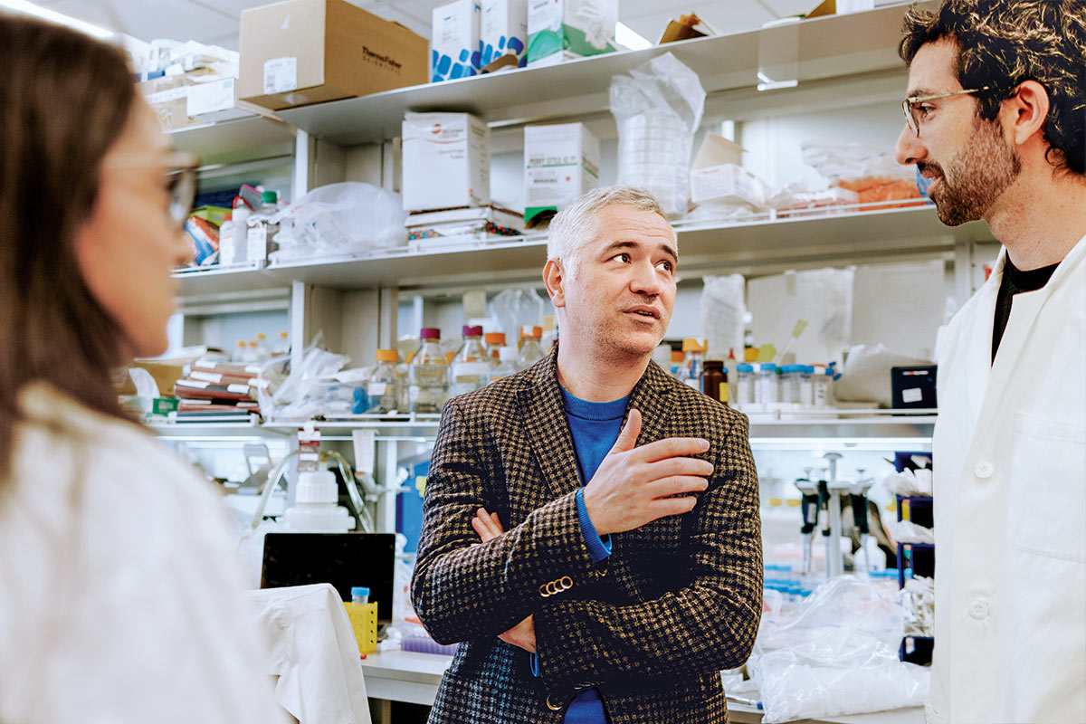 Birsoy converses with colleagues in a lab