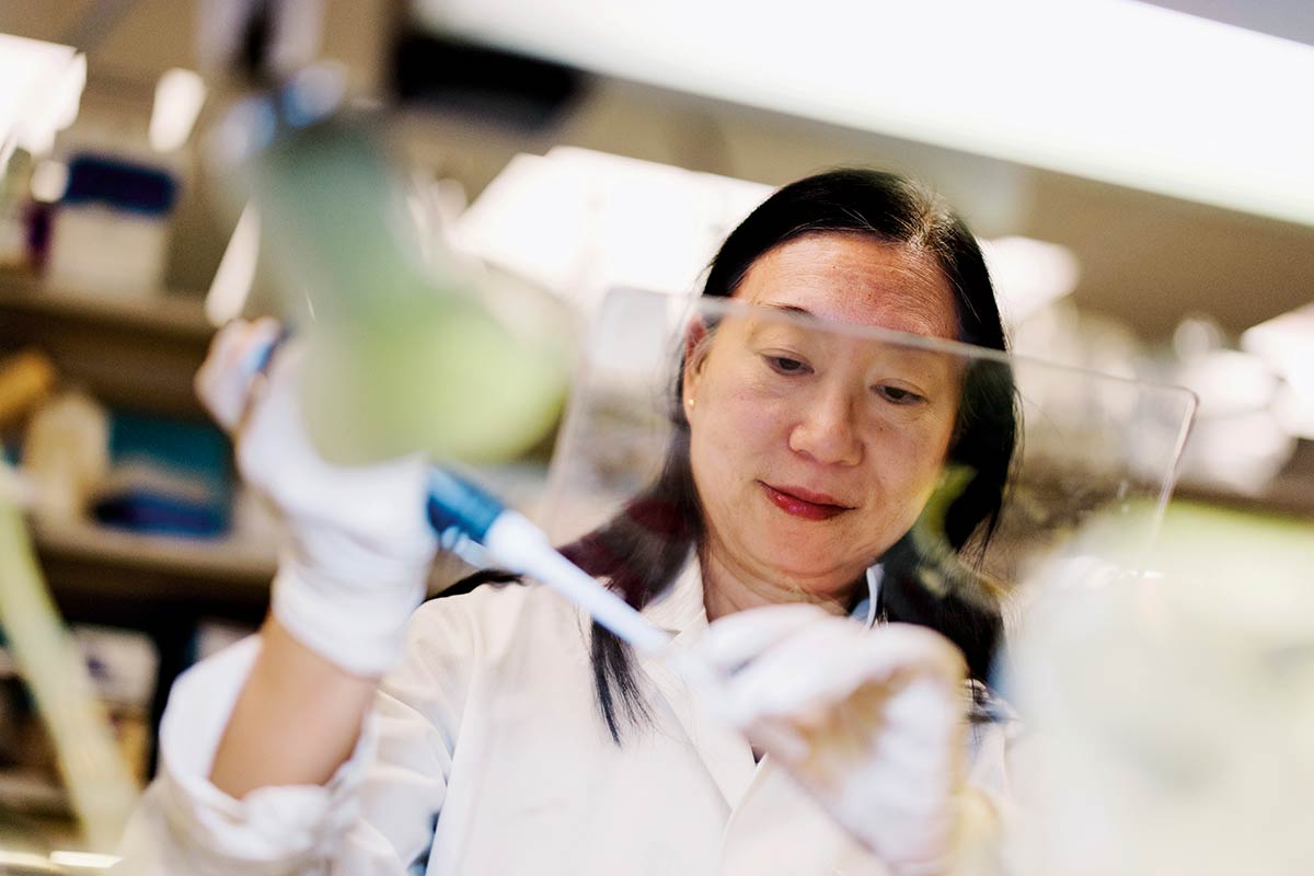 A person in a lab coat handles scientific materials
