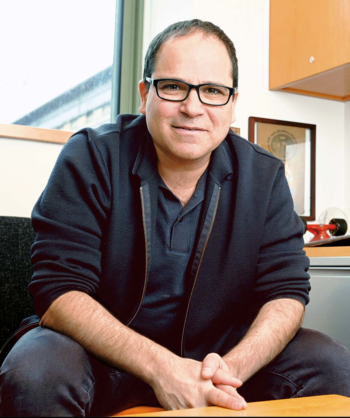 Gaby Maimon sits in their office next to a skateboard