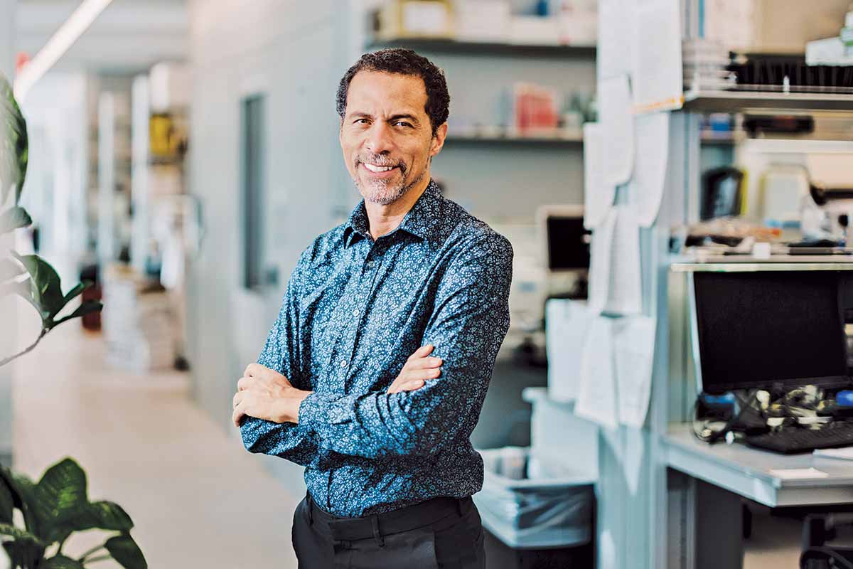 Jarvis stands with arms folded in a lab