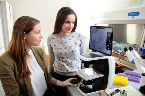 Shyer (left) with graduate student Emily Atlas at a microscope they use to study chicken embryos. Photograph by Matthew Septimus