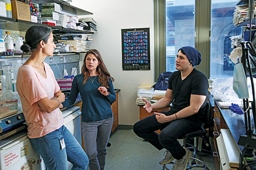 Three scientists having a discussion in a lab.