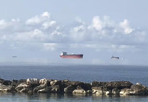 Boats floating above the ocean.